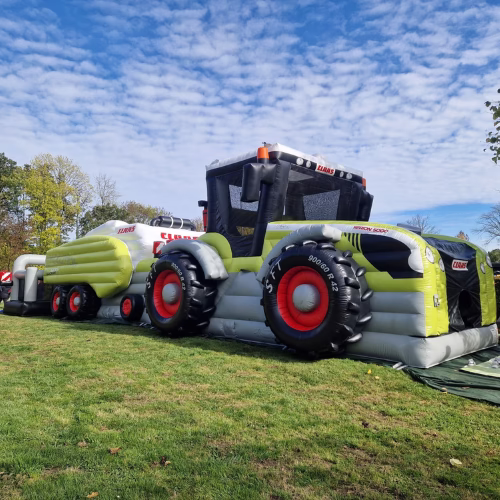 CLAAS Hüpfburg Set mit Traktor und Quaderballenpresse auf Rasen