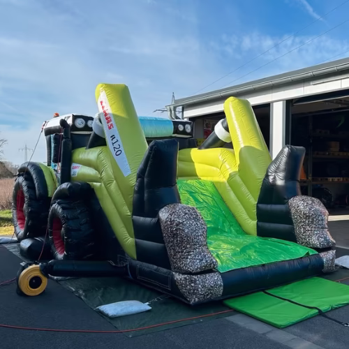 CLAAS Traktor Werbehüpfburg mit Frontlader und grüner Rutsche