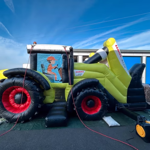 CLAAS XERION Traktor Werbehüpfburg mit Tiger Motiv vor blauem Himmel