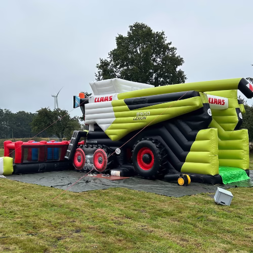 CLAAS LEXION Mähdrescher Werbehüpfburg mit rotem Schneidwerk auf Rasen